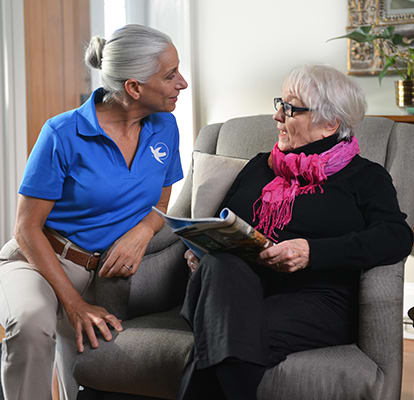 A Senior Home Care by Angels caregiver comforting an elderly woman with Alzheimer's, highlighting compassionate support in a peaceful home setting.