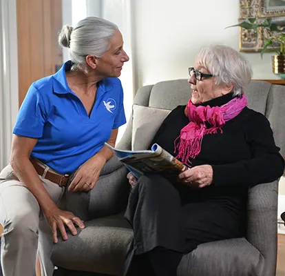 A Senior Home Care by Angels caregiver comforting an elderly woman with Alzheimer's, highlighting compassionate support in a peaceful home setting.