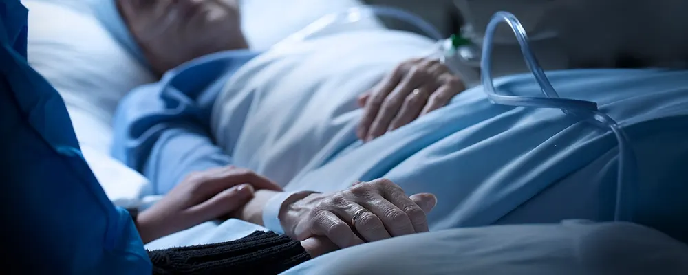 A Senior Home Care by Angels caregiver comforting an elderly woman with Alzheimer's, highlighting compassionate support in a peaceful home setting.