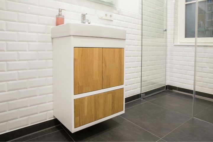 White and oak bathroom cabinet floating off the ground fixed to a wall with subway tiles for Small bathroom design ideas