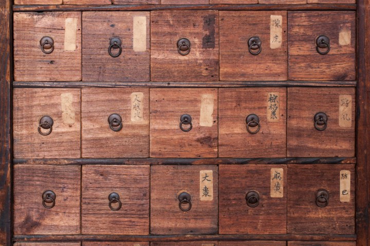 Wood medicine cabinet with many drawers. 