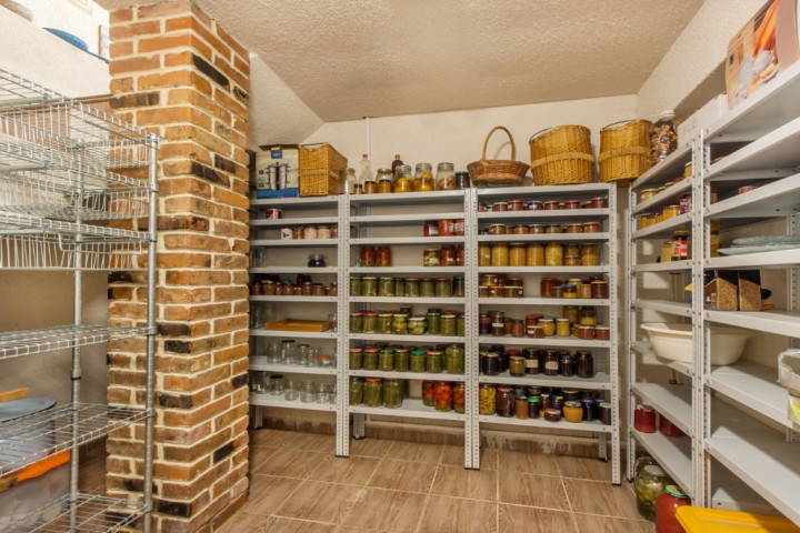 Home basement pantry with various canning jars on metal shelves