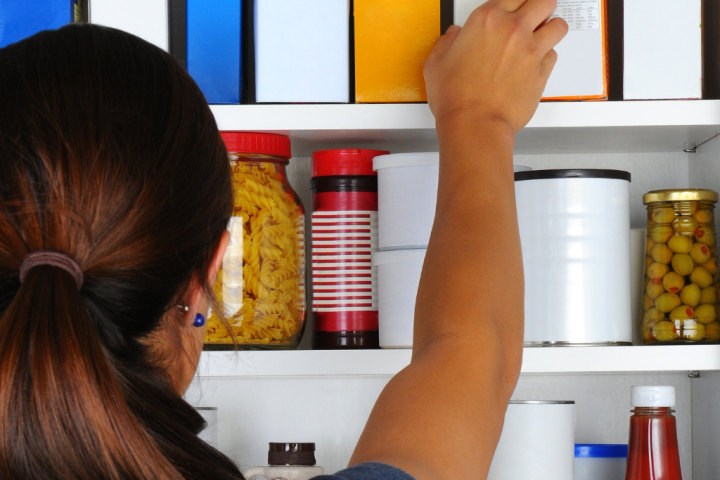 Homeowner opening doors to a fully stocked pantry