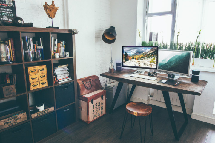 Home office with a wooden desk and bookcase with boxes and ornaments