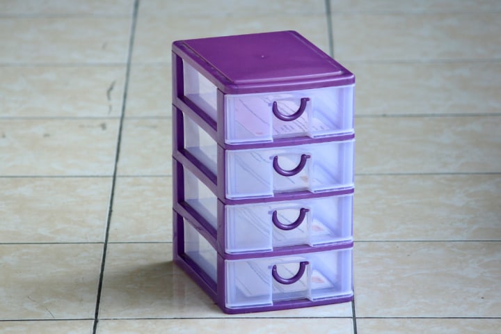 Purple transparent plastic tiered drawers on a tiled floor