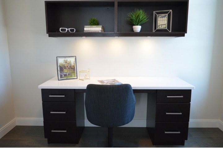 A black and white desk with matching wall shelving unit for home office storage ideas