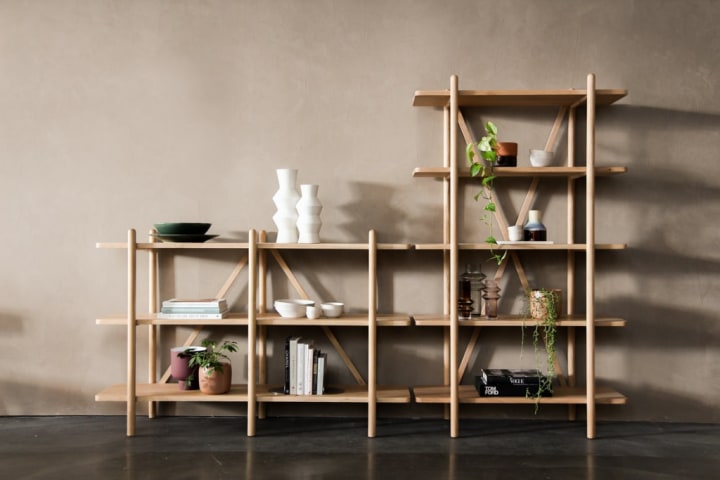 Open shelves with white vase on top and green plants