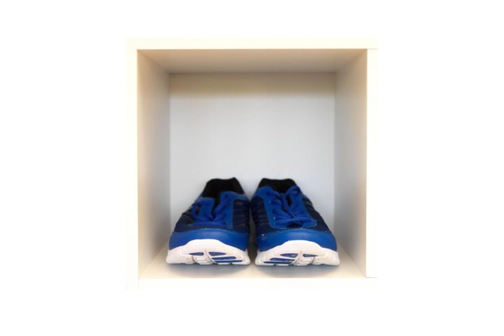 A cubbyhole with a pair of blue sneakers in it