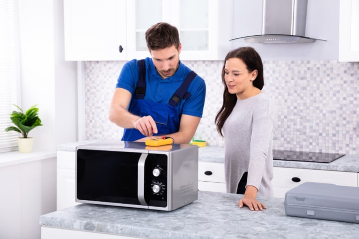 Microwave technician teaching woman