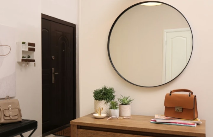 front entrance of an apartment with a mirror and dresser