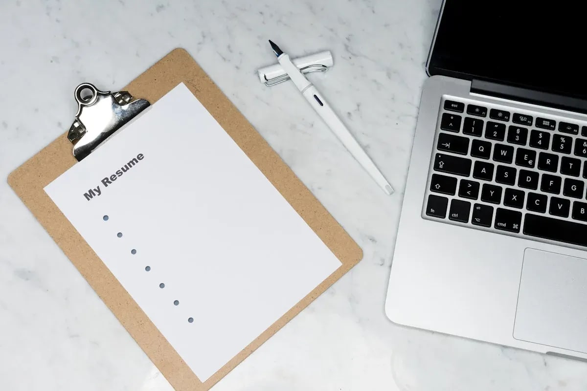A printed resume and pen on a desk
