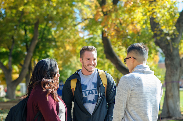 Three USU students smiling and talking.