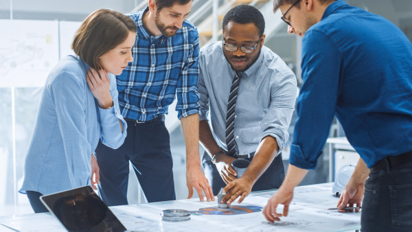 A group of professionals animatedly discussing a report on a table.