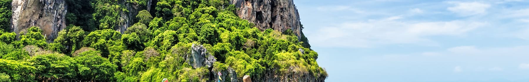 A Thai beach with traditional wooden longtail boats you might expect to see after international removals to Thailand