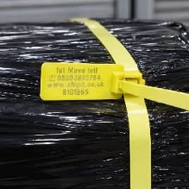 Close-up of a numbered 1st Move security seal on the strap banding.