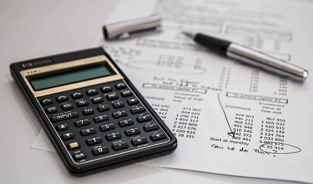Calculator and financial documents - pros and cons of living abroad