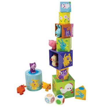 Animal Playground game stacked in a tall tower. The square, rounded, and triangle shaped boxes are in many colors with illustrations of animals and flowers on them. The plastic animal figures are randomly placed on the tower and off to the side. There is a cat figure on top of a single blue, rounded, box off to the left and a cow and dog figure on either side. There are 2 dice in front; 1 with a colored dot on each side, and 1 with the shape of an animal figure on each side.