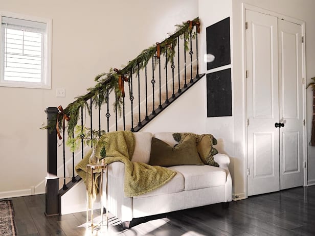 Loveseat next to a banister adorned with greenery
