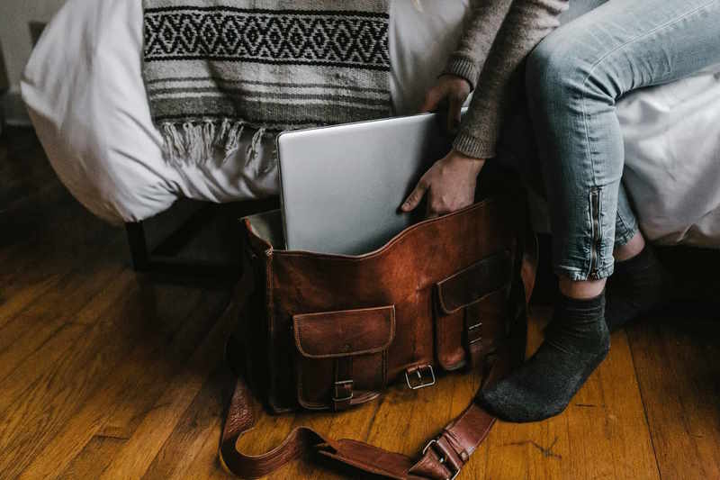 Mitarbeiter packt seinen Laptop in seine Tasche als Symbol dafür, dass er bald kündigen wird