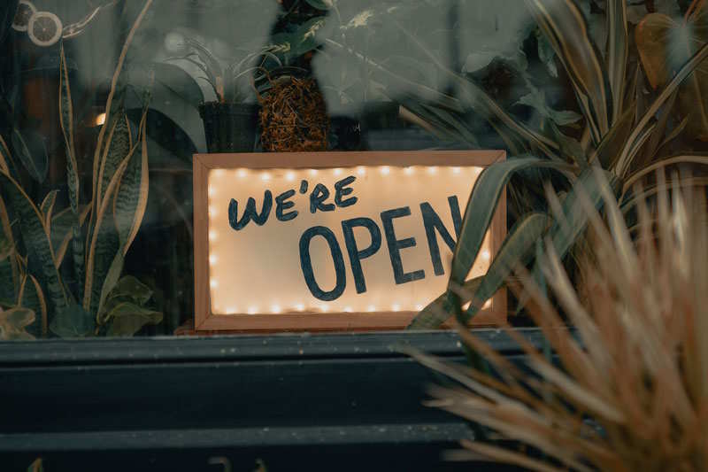 Schaufenster in dem ein Schild mit we're open steht