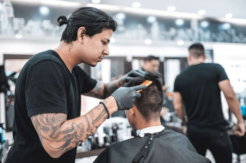 Friseur, der bei seiner Arbeit steht