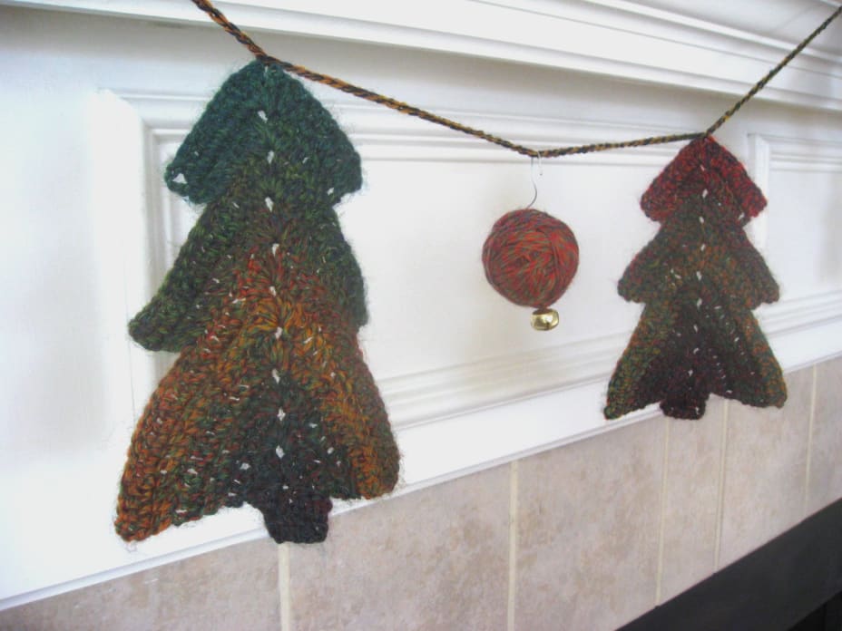 Crochet Christmas tree garland with yarn ball ornament hanging from it