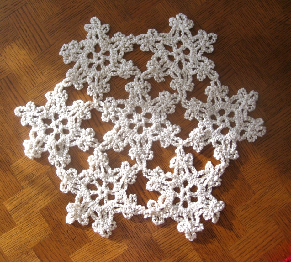 White with gold flecks yarn crocheted into a snowflake shape