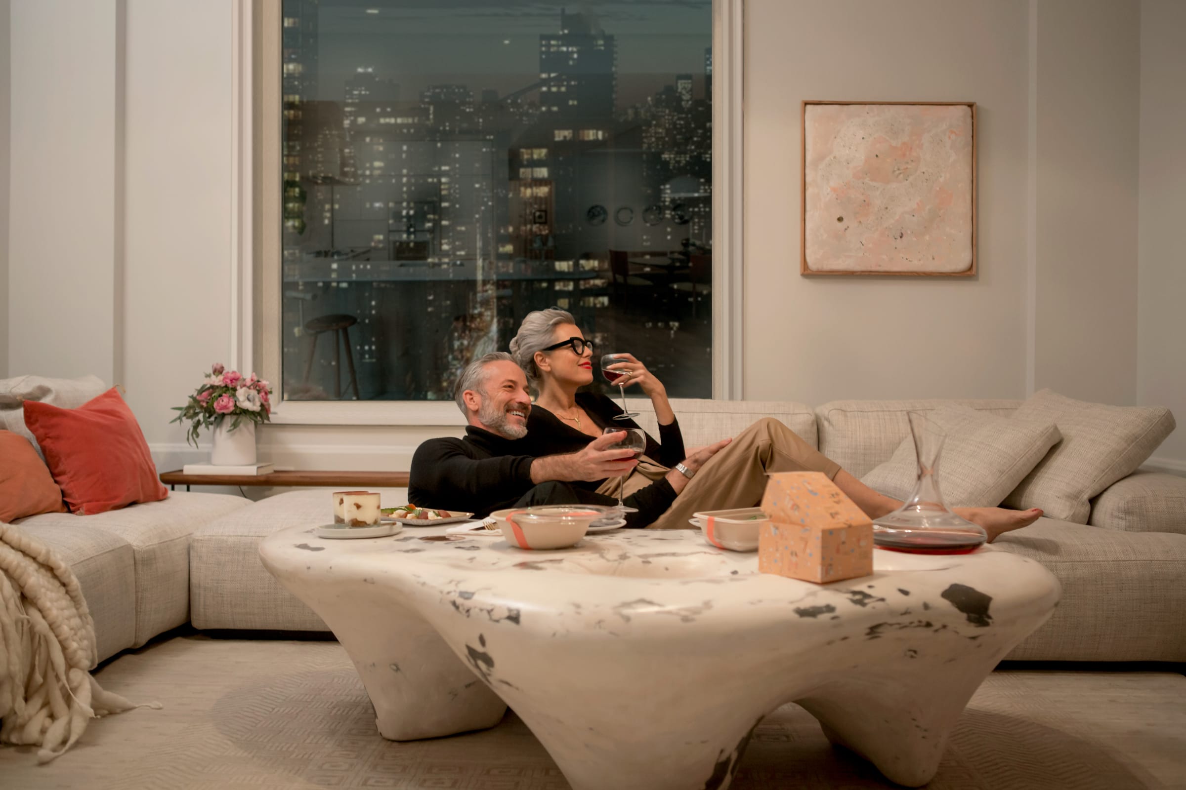 Artistic couple reclining in their living room 180 E 88th Street, a luxury condominium in the Upper East Side of Manhattan