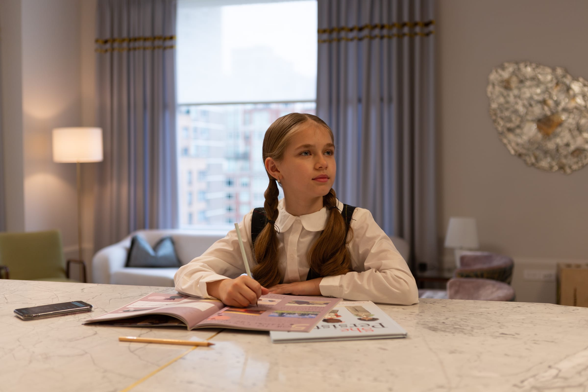 Girl looking up from homework in 180 e 88th luxury condo branding by sideways luxury real estate branding agency