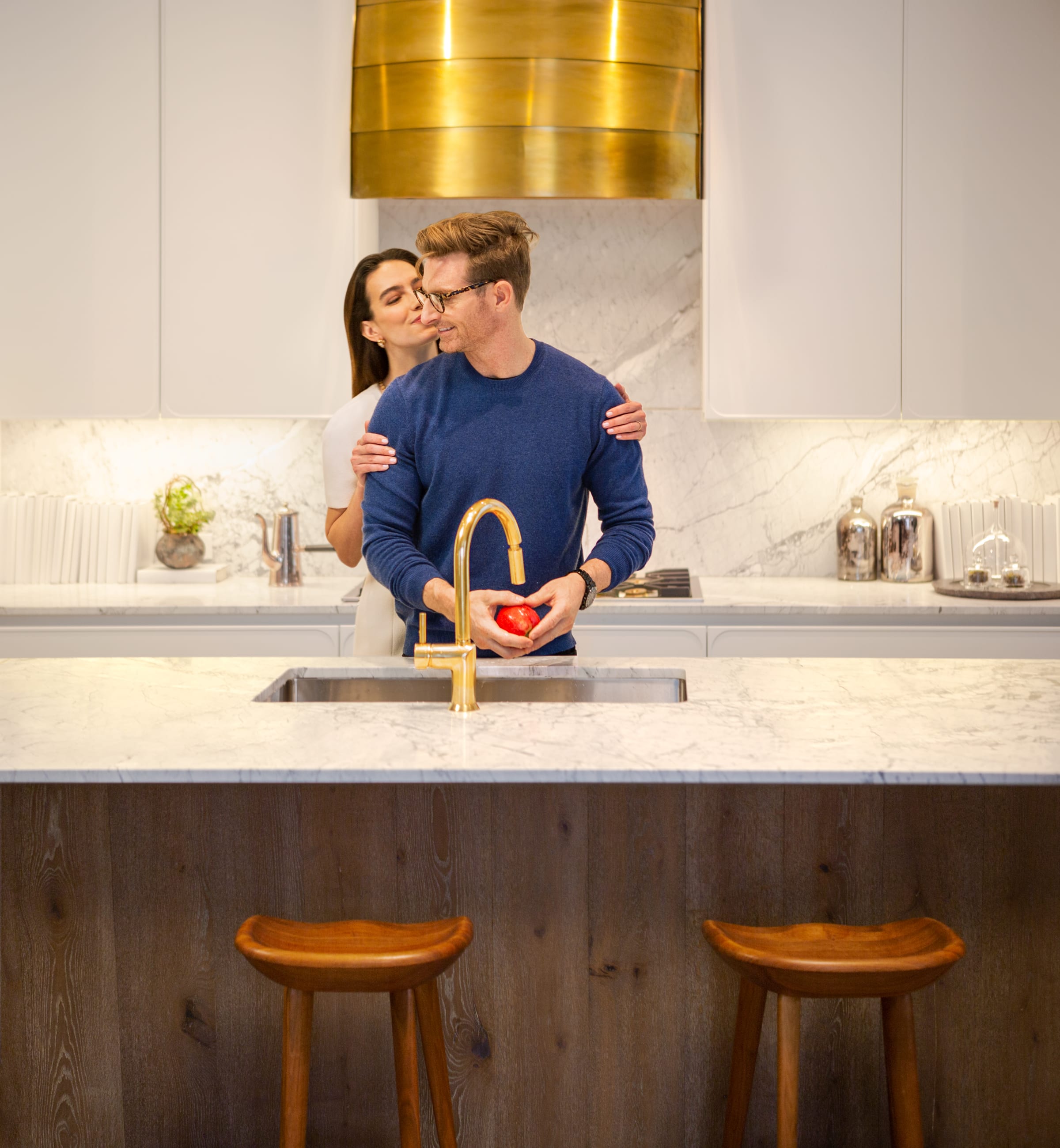 Mom greeting husband while husband is preparing dinner in their kitchen at 180 East 88th Street, a luxury condominimum on the upper east side of Manhattan. 