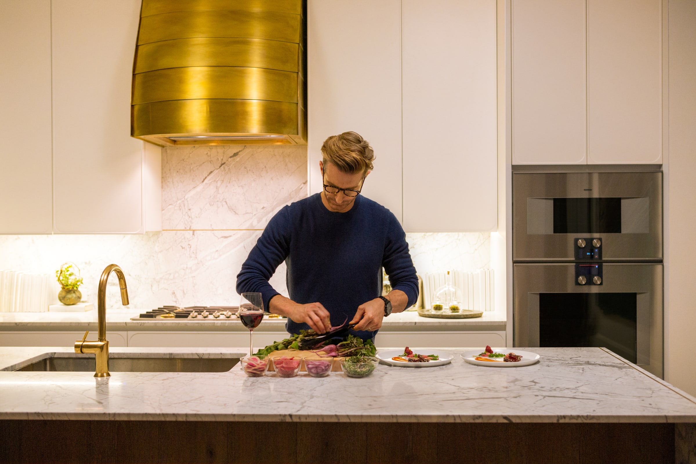 Dad preparing ingredients at large marble island in kitchen at 180 East 88th Street, a luxury condominimum on the upper east side of Manhattan. 