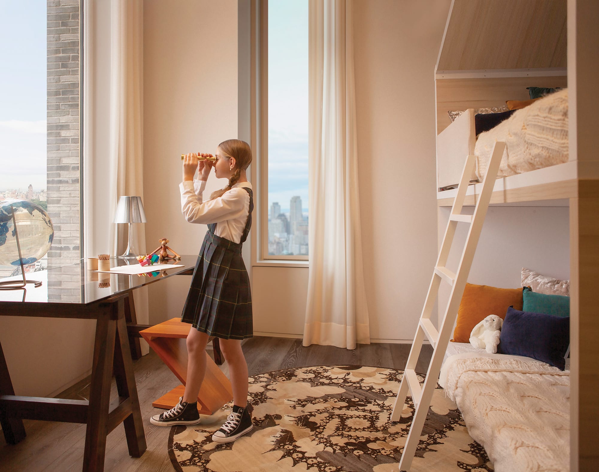 girl looking through telescope in bedroom window at 180 East 88th Street, a luxury condominimum on the upper east side of Manhattan. 