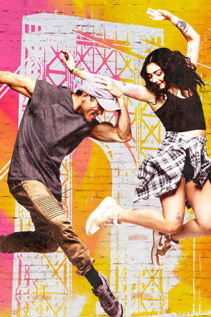Two young people energetically dancing and jumping against a pink and yellow brick background with a white image of the George Washington Bridge.