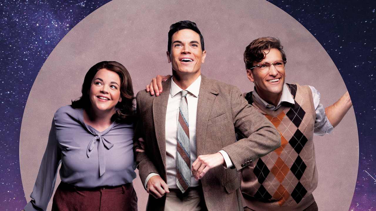 Three people step forward together, smiling and looking upward. They are framed by a moon backdrop against a starry night background.