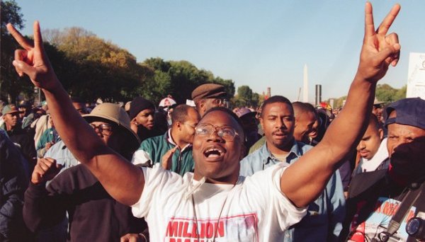 African American man holding up two peace signs at the Million Man March on the National Mall in 1995