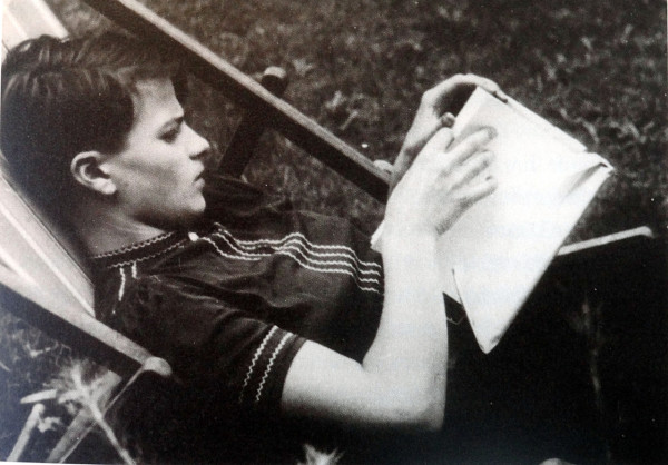 Hans Scholl reclines in a lawn chair reading a book