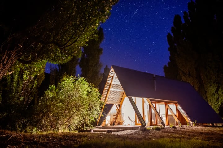Las cabañas iluminadas de noche bajo un cielo lleno de estrellas