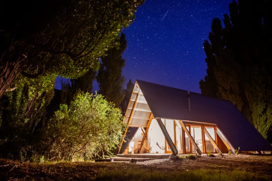 Las cabañas iluminadas de noche bajo un cielo lleno de estrellas