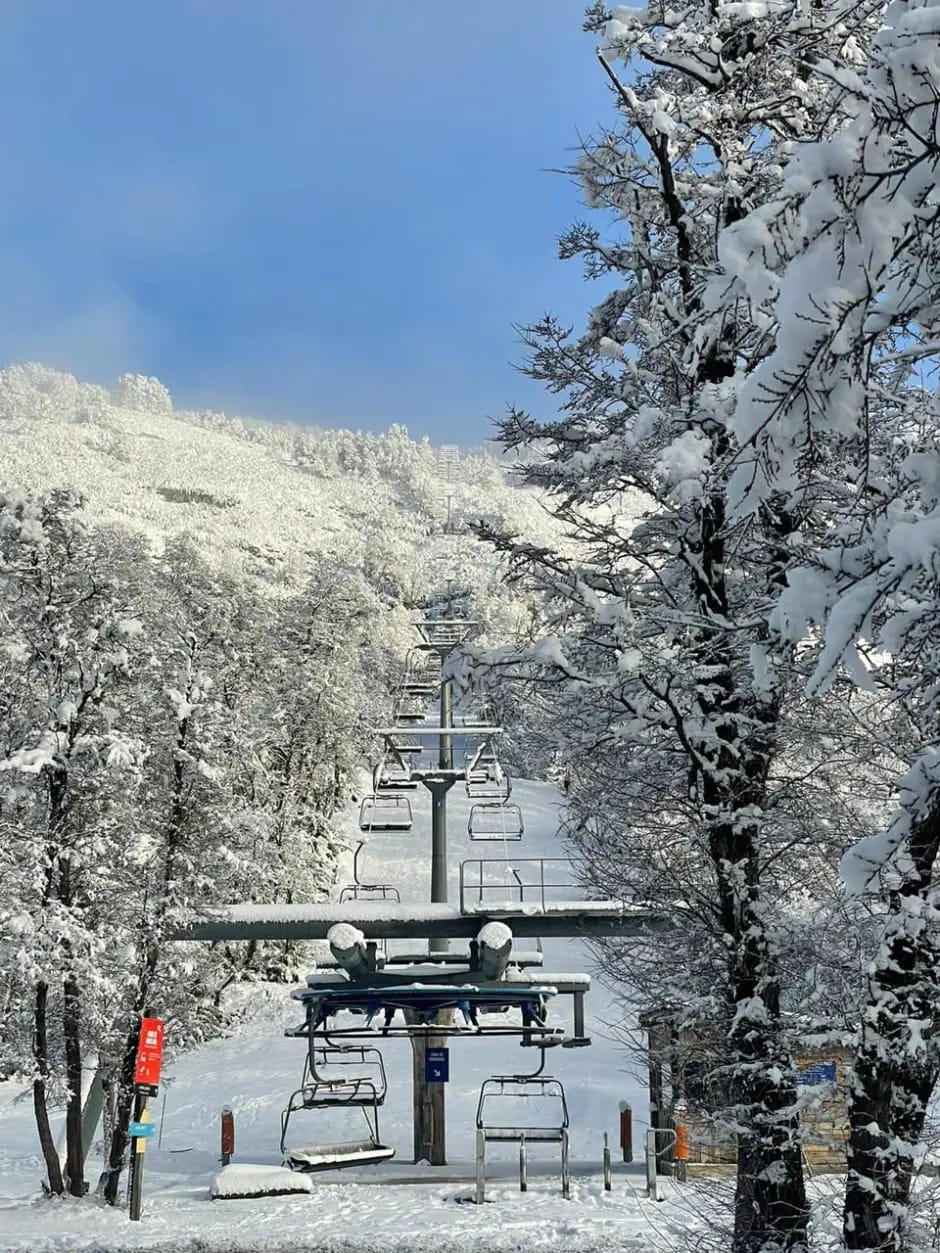 Telesilla cuádruple de Lago Hermoso Ski Resort con la pista de fondo