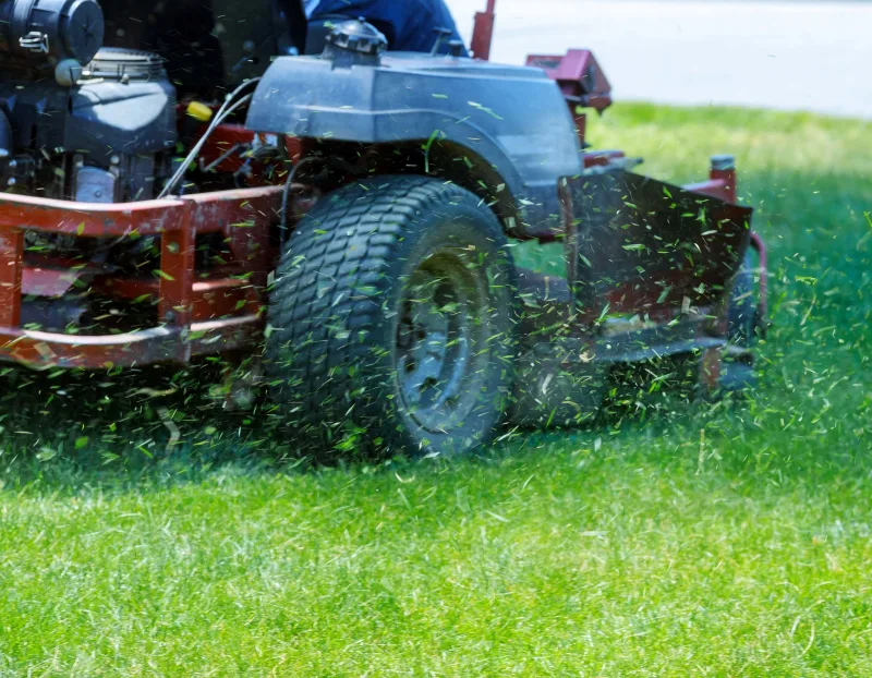 Seaside Services, Inc. providing landscaping maintenance services by mowing a lawn with a riding lawnmower