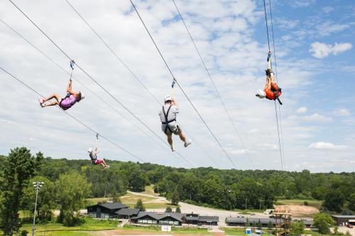 People riding the Cannonsburg Ski Area zip line