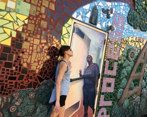 Runner posing with mural during Grand Rapids Running Tours