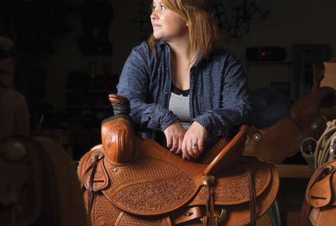 Willi Baughman leans on a saddle she made for her husband