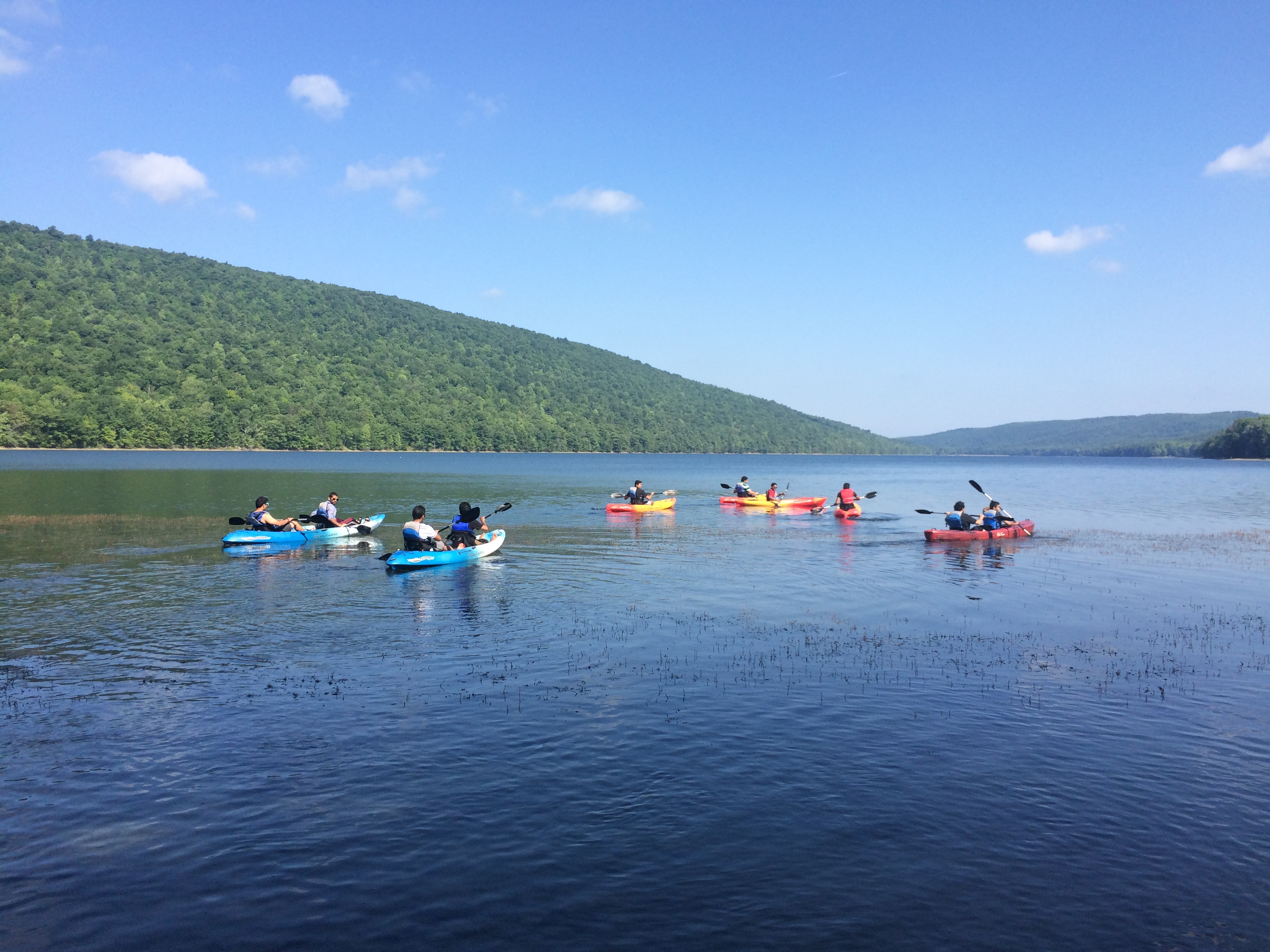 Several kayakers set out on Canadice Lake on a sunny day.