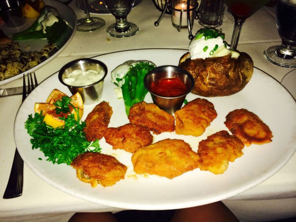 Pan fried oysters with a baked potato and steamed broccoli.