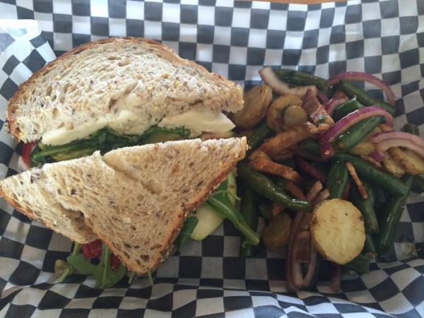 Veggie sandwich made with roasted red peppers, zucchini, pesto, arugula, ricotta and mozzarella. Green bean salad made with fingerling potatoes, bacon, red onion and basil.