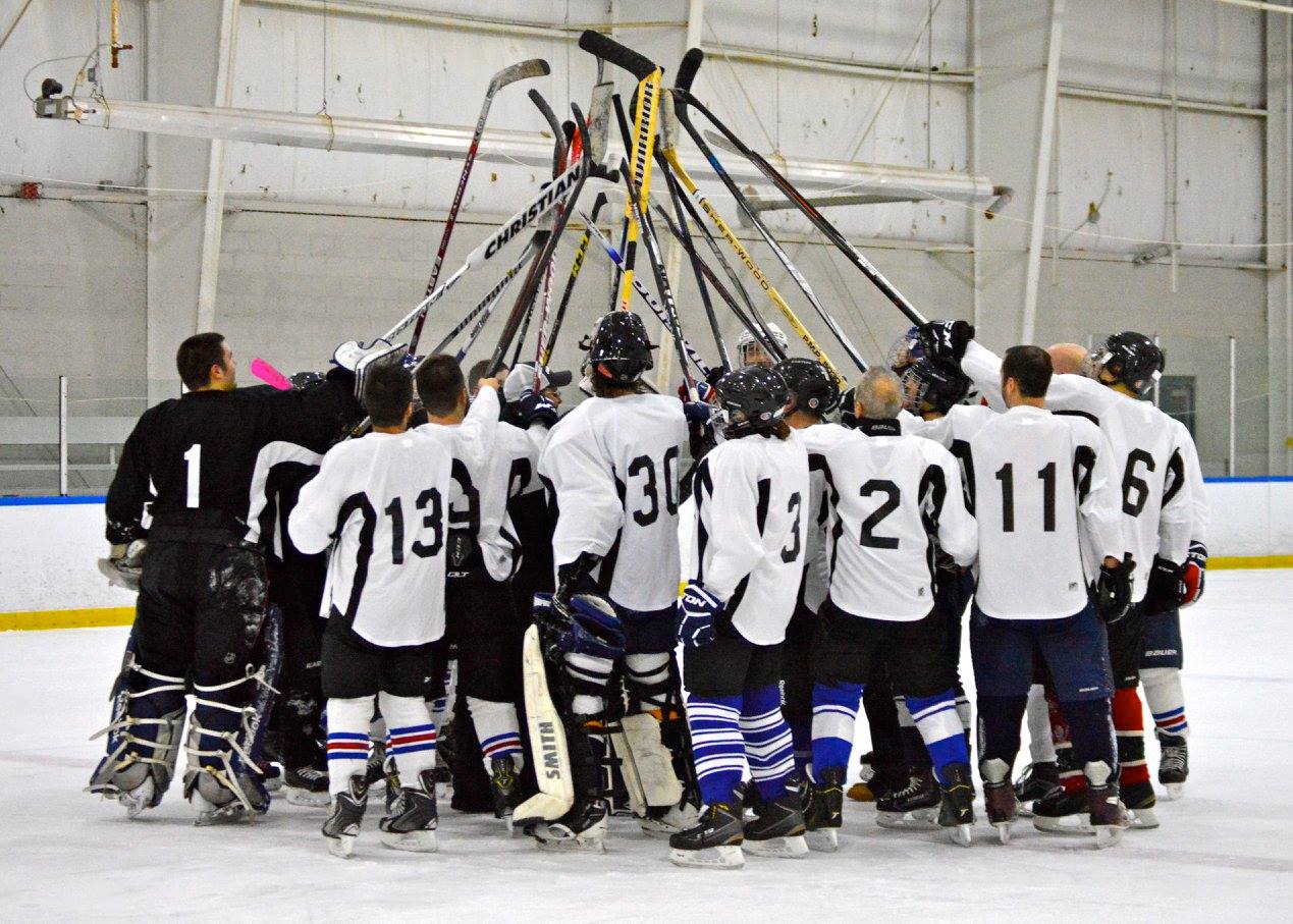 hockey players raise sticks in the air at the Rochester Bill Gray's Ice Plex