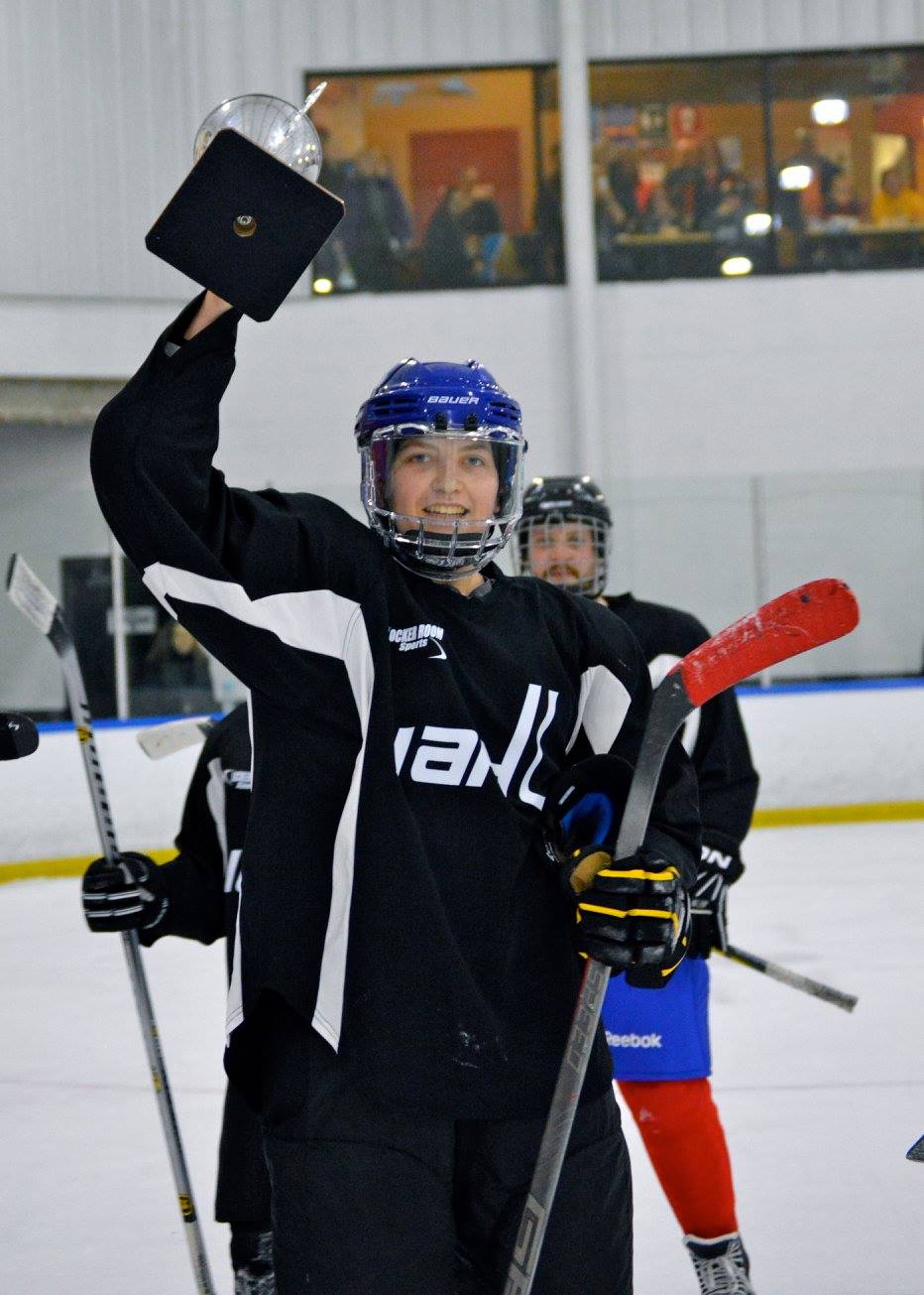 Hockey Player holds up trophy at Bill Gray's Ice Plex