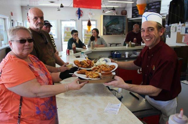 Jason Livesey, co-owner of Rudy’s Lakeside, serves up Nancy and Rick Brower, of Syracuse. Livesey and his wife, Julie, co-owner, have joined forces with I Heart Oswego to create an insert for the restaurant’s boxes, which will advertise local small business for free. The box inserts will be included with customers’ orders during its season in the hopes to drive more business to the Oswego area.