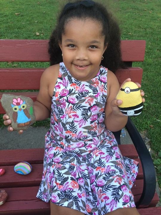 Child with minion and owl painted rocks